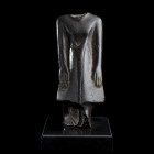 * STATUETTE DE DIGNITAIRE 
En basalte, figuré debout, les pieds joints, les bras serrés le long du corps, ses mains reposant sur son long pagne. Le t...