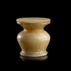 VASE KOHOL ET SON COUVERCLE 
En albâtre, à panse carénée. Le bord est en forme d'entonnoir et le pied renforcé par un bourrelet. 
H. 6 cm ; Diam. 5,...