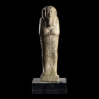 USHABTI DE HOR IR AA
En faïence grise. Figuré dans sa gaine momiforme, les mains croisées tient les houes. Il porte une perruque tripartite laissant ...