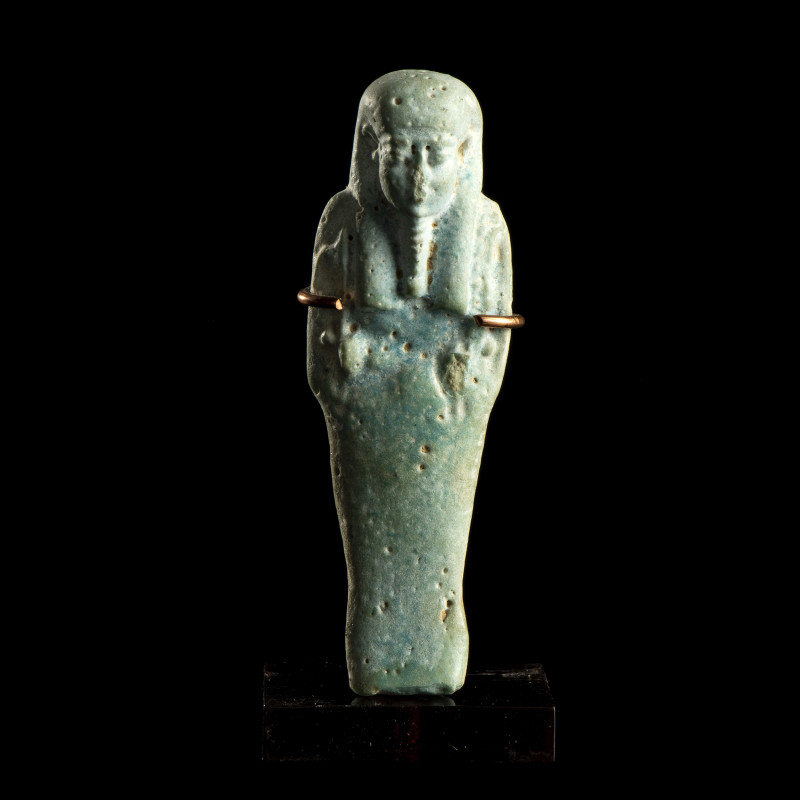 USHABTI
En faïence bleue, dans sa gaine mommiforme; perruque tripartite. Anépig...