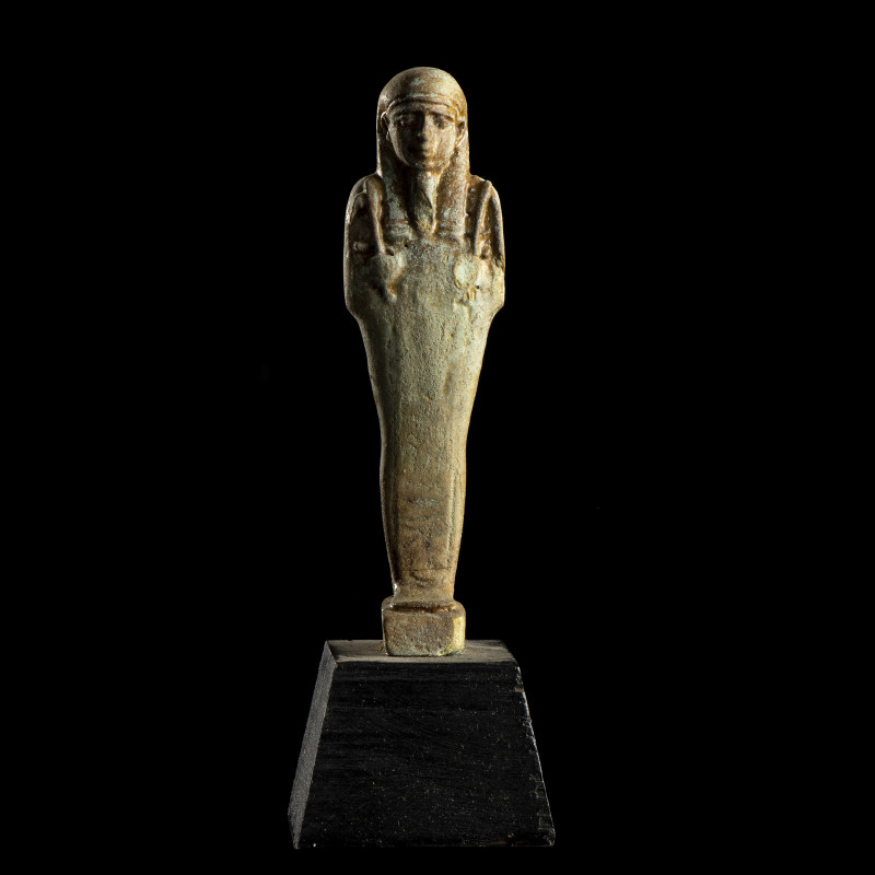 USHABTI
En faïence, dans sa gaine mommiforme ; anépigraphe. 
H. 11,5 cm. 
Egy...