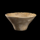 COUPE
En calcite, largement évasée et étranglée vers le bas. Pied large discoïdal. Lèvre ébréchée.
H. 5,5 cm ; Diam. 11,5 cm. 
Proche-Orient, IIe m...