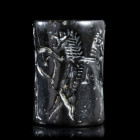 SCEAU-CYLINDRE
Surhématite.
La scène figure un combat entre un homme ; deux lions et deux zébus. 
H. 32 mm ; Diam. 22 mm.
Empire d'Agadé, v. 2300-...