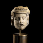 TÊTE DE COMÉDIEN
En terre-cuite. Caractérisée par un visage arrondi, des yeux grands ouverts encadrés par des paupières ourlées. La bouche grande ouv...