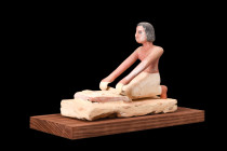 EGYPTIAN WOODEN MODEL OF A WOMAN GRINDING GRAIN

 Middle Kingdom, ca. 2030-1650 BC
 A model of a woman grinding grain is a captivating artifact cra...