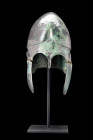 STUNNING GREEK CHALCIDIAN BRONZE HELMET

 Ca. 500-300 BC
 A helmet of hammered bronze. The domed crown with frontal medial ridges, contoured double...