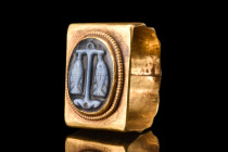 ROMAN GOLD RING WITH ONYX INTAGLIO WITH ANCHOR AND FISH

 Ca. 400 AD
 A gold D-shaped finger ring with its broad and flat-section hoop, adorned wit...