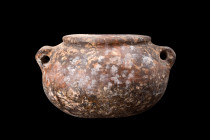 EGYPTIAN STONE VESSEL

 Early Dynastic Period, ca. 2900-2600 BC
 A stone vessel features a bulbous body that elegantly emerges from a circular base...