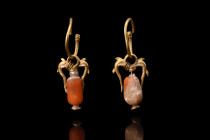 MATCHED PAIR OF GREEK HELLENISTIC GOLD EARRINGS WITH DOLPHINS

 Ca. 400 BC
 A pair of gold earrings of a round hoop as the centerpiece, from which ...