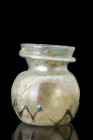 ROMAN GLASS JAR WITH BLUE TRAILING DECORATION

 Ca. 300-400 AD
 A free-blown glass jar of a squat form, characterized by a concave base and a globu...