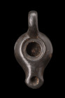 GREEK BLACK-GLAZE TERRACOTTA OIL LAMP

 Ca. 400-300 BC
 A pottery oil lamp adorned with a black glaze. It features a hollow rounded body with a cen...