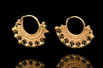 MATCHED PAIR OF GREEK HELLENISTIC GOLD EARRINGS

 Ca. 4th-1st century BC
 A matched pair of gold earrings boasts a crescent-shaped design that is e...