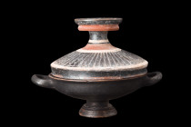 GREEK LEKANIS WITH DECORATIVE LID

 Ca. 350-300 BC
 A pottery lekanis consisting of a shallow bowl, with its black glaze, opposing loop handles, st...