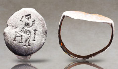Greek Silver Ring with Seated Goddess, 5th-3rd century B.C. A silver ring composed of a D-section hoop and large discoid bezel, engraved with a goddes...