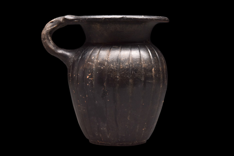 GREEK BLACK GLAZE CUP WITH HANDLE

 Ca. 340-325 BC
 A blackware pottery cup w...