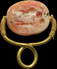 An etruscan intaglio on a burnt carnelian scarab, mounted in an ancient gold seal. Mythological scene. A standing male character is leaning on a knobb...