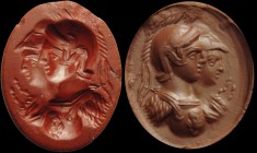 A roman red jasper intaglio. Conjoined busts of Mars and Athena, both turned to the left. Each deity is wearing a helmet with crest; Athena is wearing...