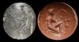 A roman rock crystal intaglio. A satyr with a lyre. The figure is crouched, with a knee on the ground, playing the lyre, with an orizontally kept thyr...