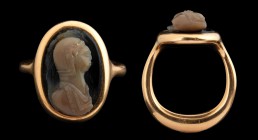 A roman double-layer agate cameo, mounted in a modern, gold ring. Helmeted bust. The effigy, turned to the left, is wearing the chlamys, showing a nak...
