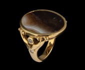 A banded agate intaglio, mounted in a modern gold ring, 18k, with four diamonds bright cut. Two characters, with twigs. A standing female figure (prob...