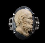 A white gold ring with diamonds, with an onyx cameo mounted on. Head of Socrates, turned to the right. The work is characterized by a remarkable, well...