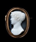 An onyx cameo, by A. Berini, mounted in a gold brooch. Portrait of a noblewoman from the napoleonic period, in profile to the left, signed BERINI (Ant...