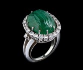 An emerald intaglio, mounted on a modern grey gold ring, surrounded by diamonds. Naked female figure, holding a drape. Cabochon-cut stone. Ground line...