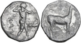 Greek Italy. Bruttium, Kaulonia. AR Stater, c. 475-425 BC. Obv. KAV. Apollo advancing right, branch in raised right hand; Daimon running on extended l...