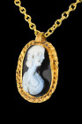 Ca. 200 AD.
A gold ovoid pendant with a suspension loop and a rope-patterned border enclosing a white on black sardonyx cameo depicting a bust of Juli...
