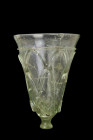 Ca. 500-700 AD.
A pale green cut glass beaker of a conical shape, standing on a small, rounded foot, providing balance and stability. The exterior wal...