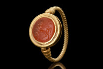 Ca. 200 AD.
A gold finger ring composed of a round hoop that has been formed of a thin rod with a twisted effect, resulting in a unique and ornate des...