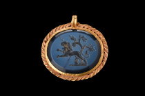 Ca. 200-300 AD.
A nicolo intaglio pendant finely engraved with a scene of a majestic lion advancing near a tree, with intricate details that capture t...