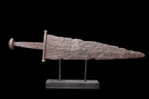 Ca. 900-1100 AD.
An iron military dagger comprising a short triangular blade with thick midrib and tapering edges, narrow point, cross guard with cham...
