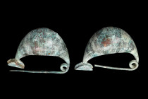 Ca. 700-600 BC.
A pair of bronze brooches, Sanguisuga type. Each brooch features a thick arched bow, a long catch, a two-coiled spring, and a straight...
