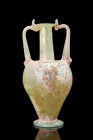 Ca. 200 AD.
A glass amphoriskos, an exemplar of artistic finesse, exhibits a captivating inverted piriform contour, with a distinctive button base, a ...