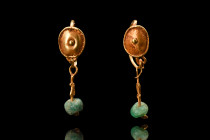 Ca. 100-200 AD.
A lovely pair of gold earrings comprised of a delicate hoop, secured with a hook and eye closure, and adorned with a boss shield. The ...