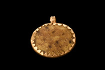 Ca. 400-300 BC.
An elegant pendant with an oval-shaped insert encased in a gold frame with a serrated edge and a suspension loop. The oval-shaped inse...