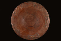 Ca. 100 AD.
A rich red terra sigillata bowl of a hemispherical body with a broad, flat rim with a decorative relief pattern of five zoomorphic beasts ...