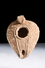 Ca. 600-700 AD.
A terracotta oil lamp, characterized by a flattened and pointed reservoir. This lamp features a non-protruding spout, thoughtfully des...