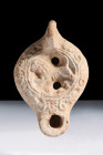 Ca. 100-300 AD.
A terracotta oil lamp characterized by its round body, sunken tondo featuring a finely detailed lion facing left, and a single beak. T...