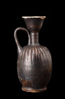 Ca. 5th century AD.
A black-glaze lekythos displays a roundish body that rests upon a ring base, providing stability and balance to the vessel. Notabl...