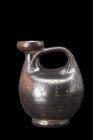Ca. 480-450 BC.
A black-glaze askos crafted from clay showcases a globular body with a mouth that is tilted to one side. It is also equipped with a ho...