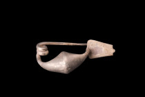 Ca. 5th-4th century BC.
A silver fibula featuring a broad and hollow bow with an elegant catchplate. The pin, crafted with great precision, tapers to ...
