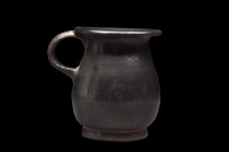 Ca. 400-300 BC.
Fashioned from pottery, this cup exhibits a captivating and distinct aesthetic. Its surface is entirely adorned with a lustrous black ...