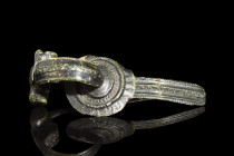 Ca. 1st century AD.
A bronze rosette brooch with a central round panel, distinguished by double raised bands and intricate moulded decorations, evokin...
