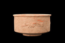 Ca. 200-300 AD.
A terracotta cup featurng a round cylindrical body resting on a raised base, with straight walls that flare out at the rim. The cup is...