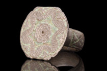Ca. 300 AD.
A bronze ring featuring a round hoop, meticulously decorated with incised 'X' motifs, adding an intricate and captivating design element. ...