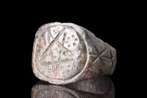 Ca. 400-500 AD.
A bronze ring boasting a broad, flat-sectioned hoop with pairs of incised crosses on its shoulders. The hoop expands to form a bezel ...