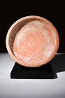 Ca. 100-300 AD.
A redware plate with an expansive countenance, characterized by its wide and rounded form, is gracefully poised upon a dignified ring ...