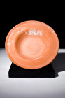 Ca. 100-300 AD.
A redware plate fashioned with a shallow and rounded countenance showcases a broad flange encircling the basin. A delicate mantle of e...